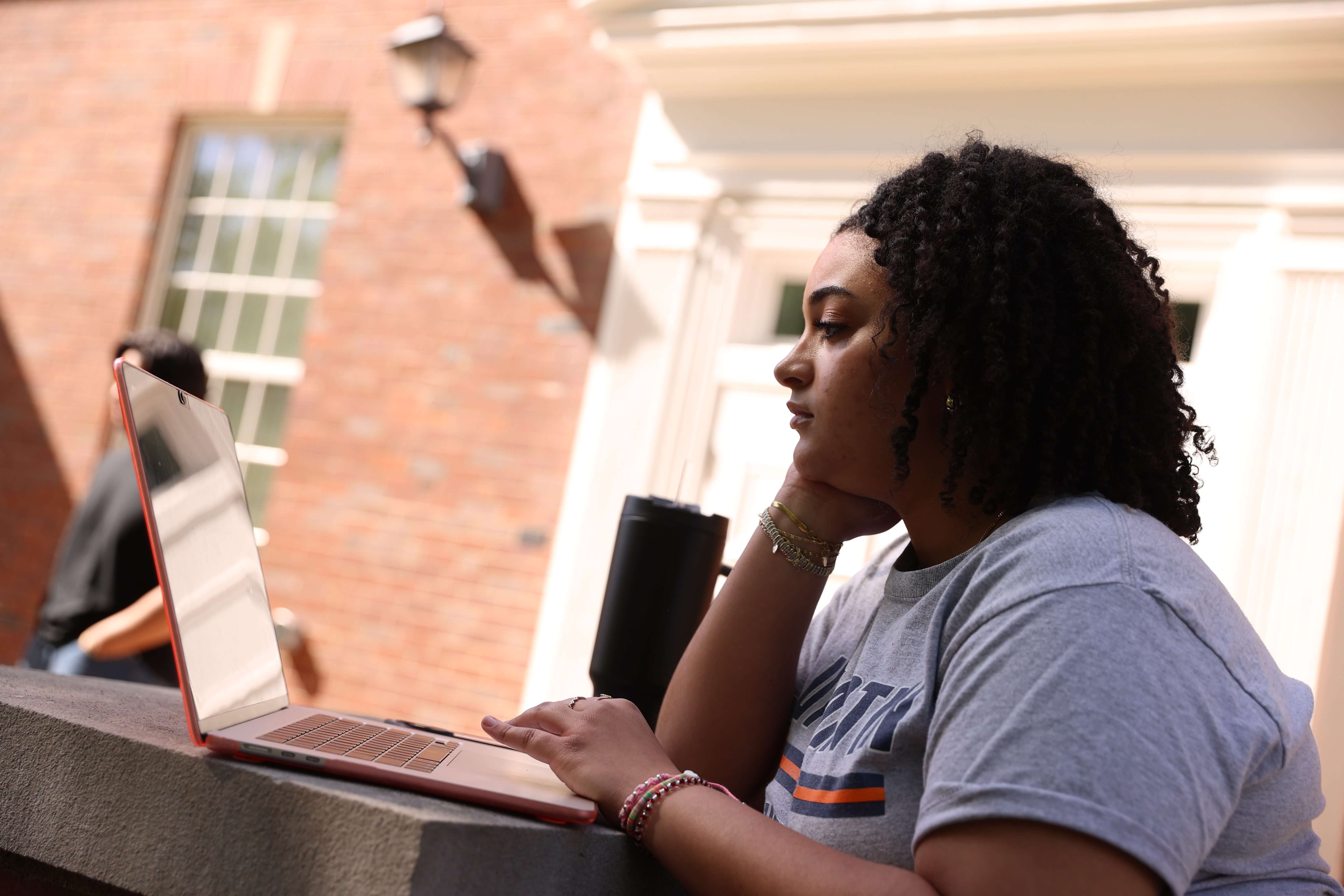 Student studying on their laptop on the UTM quad.